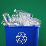 A recycling bin stuffed with plastic water bottles