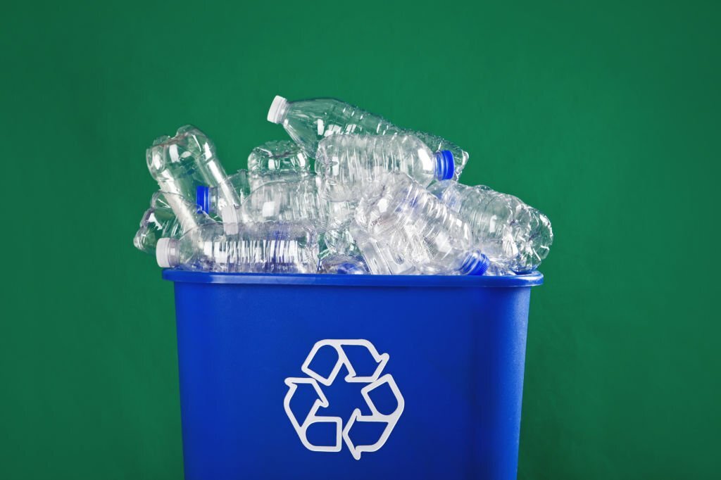 A recycling bin stuffed with plastic water bottles